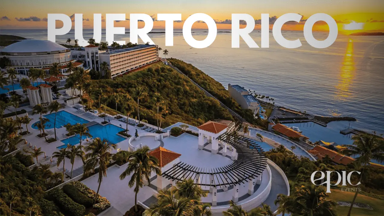 A breathtaking sunset view over the Conquistador resort, with vibrant orange and pink hues reflecting on the ocean, framed by the resort's lush tropical grounds.