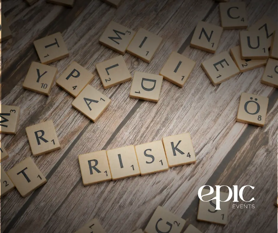 Scrabble tiles spelling the word “RISK” on a wood surface, symbolizing risk management in events, with the Epic Events logo in the corner.